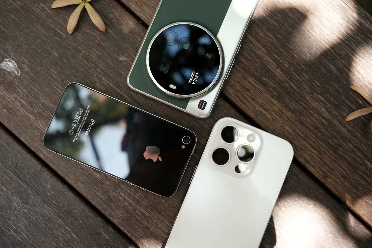 Overhead composition of multiple smartphones on a wooden surface, highlighting contemporary technology.